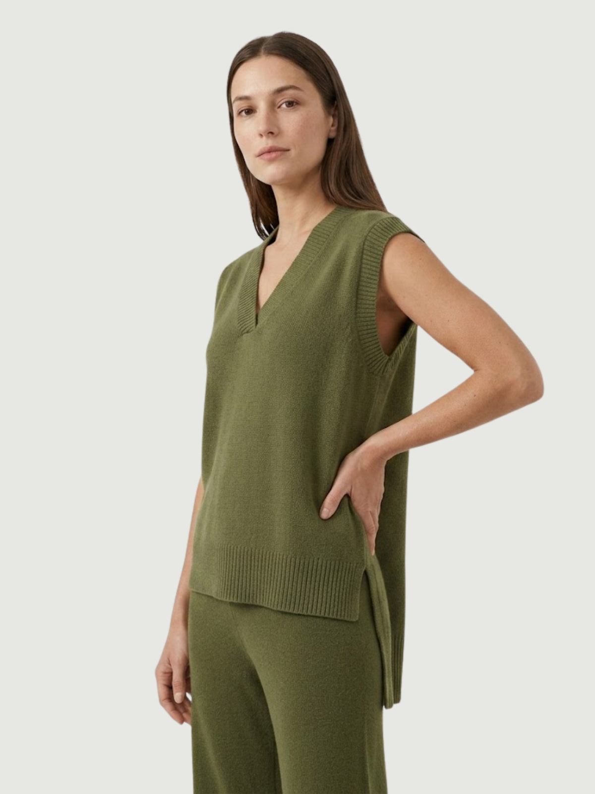 Vista laterale modella indossa gilet over color oliva con scollo a V taglio asimmetrico