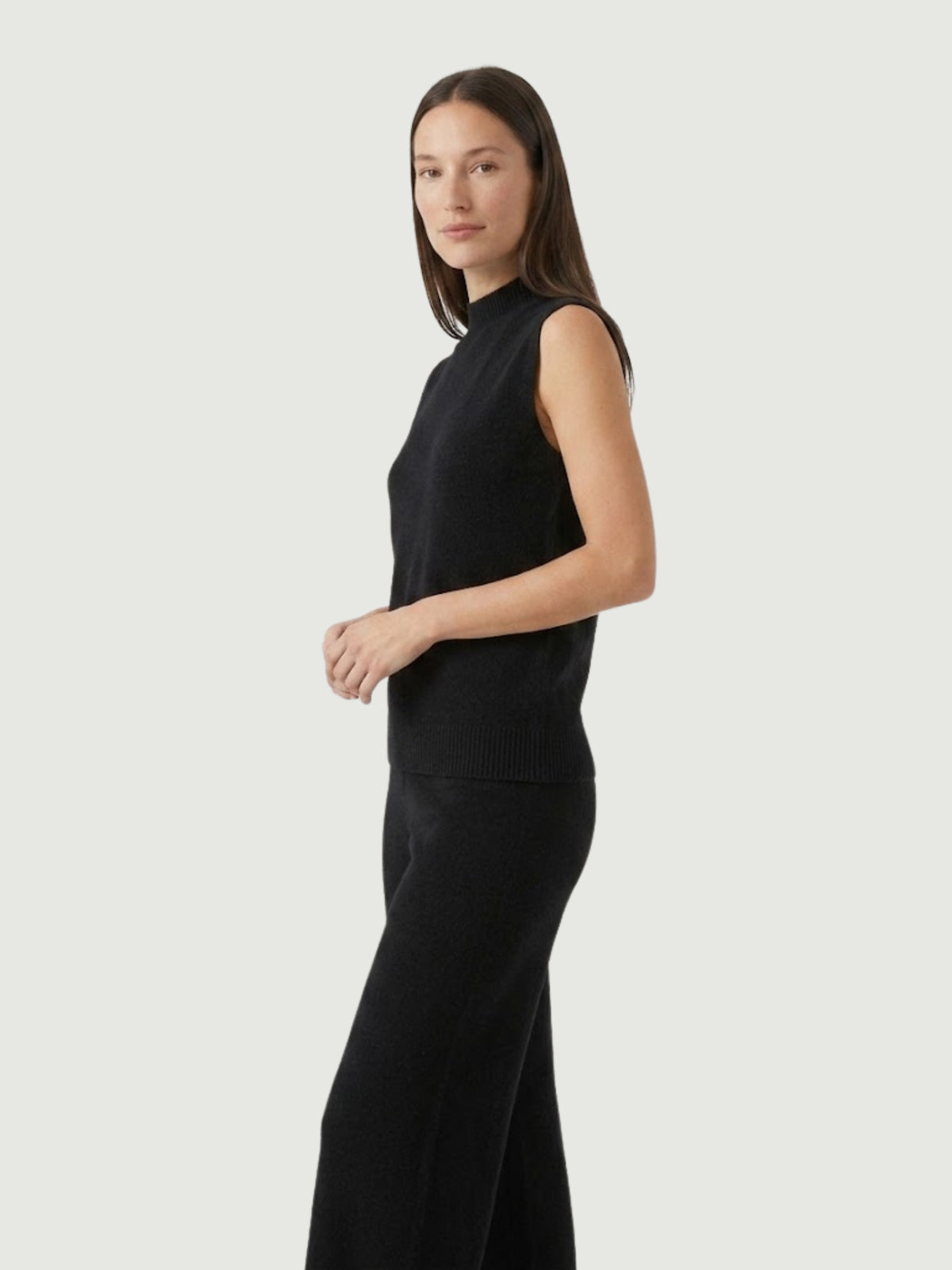 Vista laterale modella indossa gilet smanicato con collo a lupetto nero