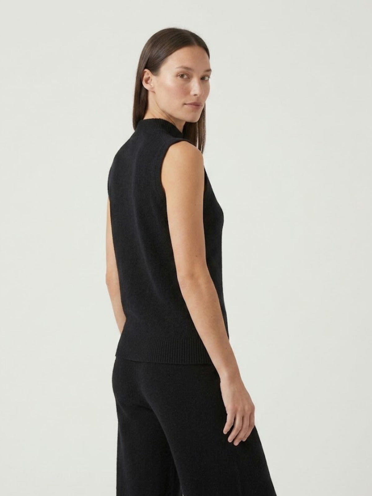 Vista posteriore modella indossa gilet smanicato con collo a lupetto nero