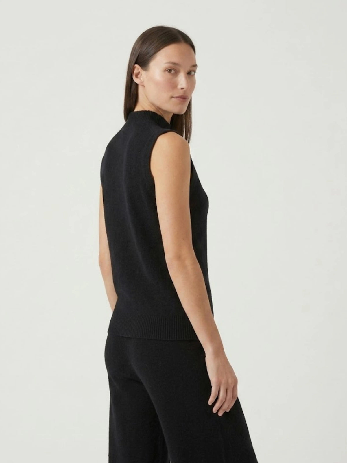 Vista posteriore modella indossa gilet smanicato con collo a lupetto nero