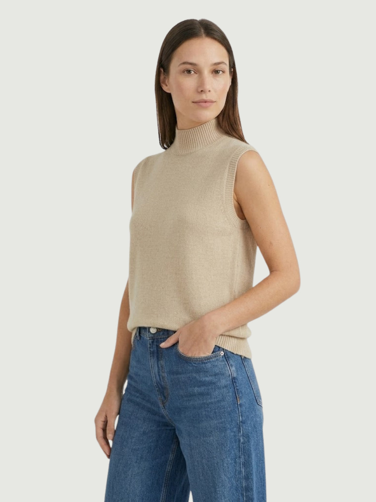 Vista laterale modella indossa gilet smanicato con collo a lupetto beige