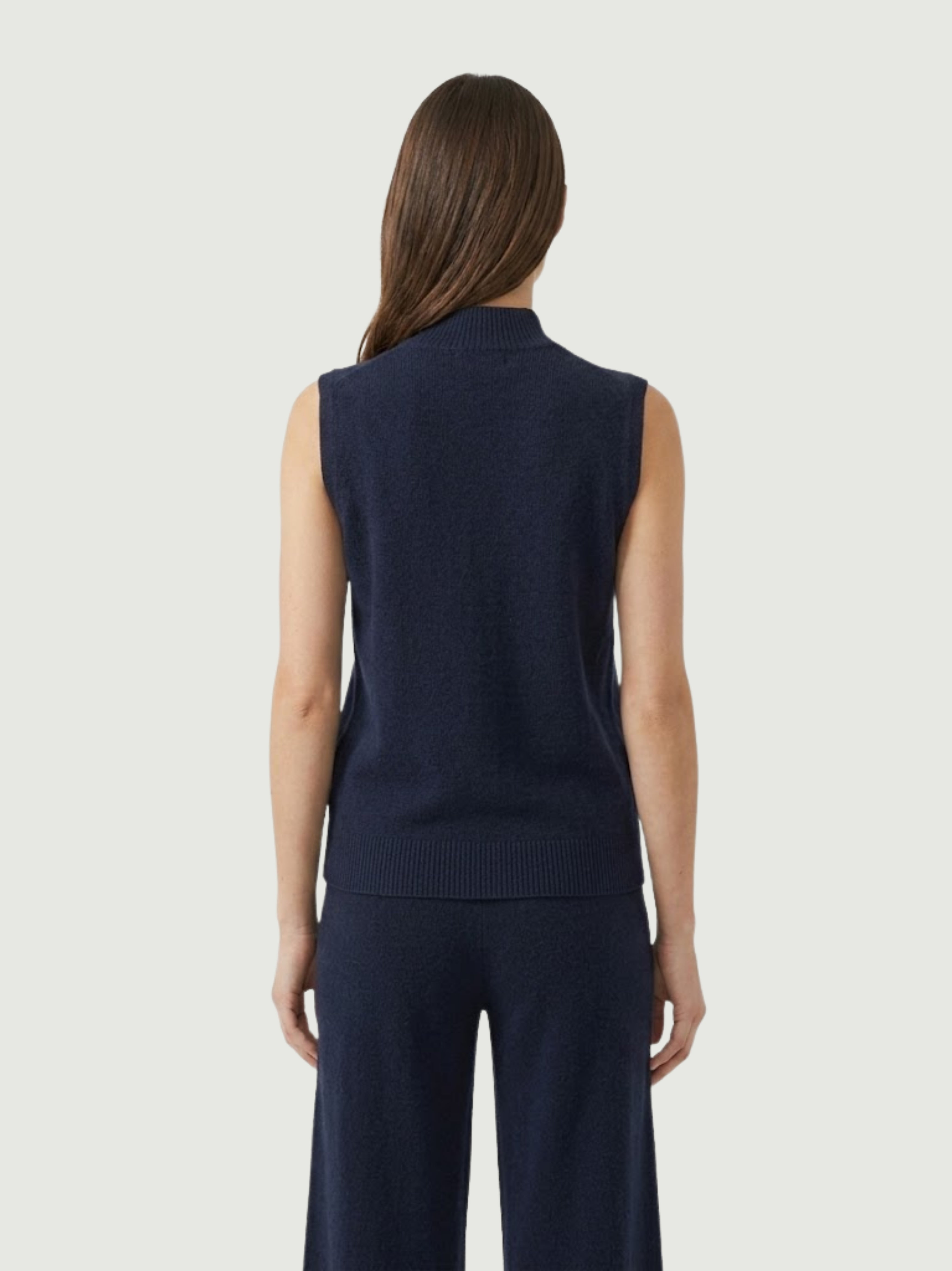 Vista posteriore modella indossa gilet smanicato con collo a lupetto blu scuro