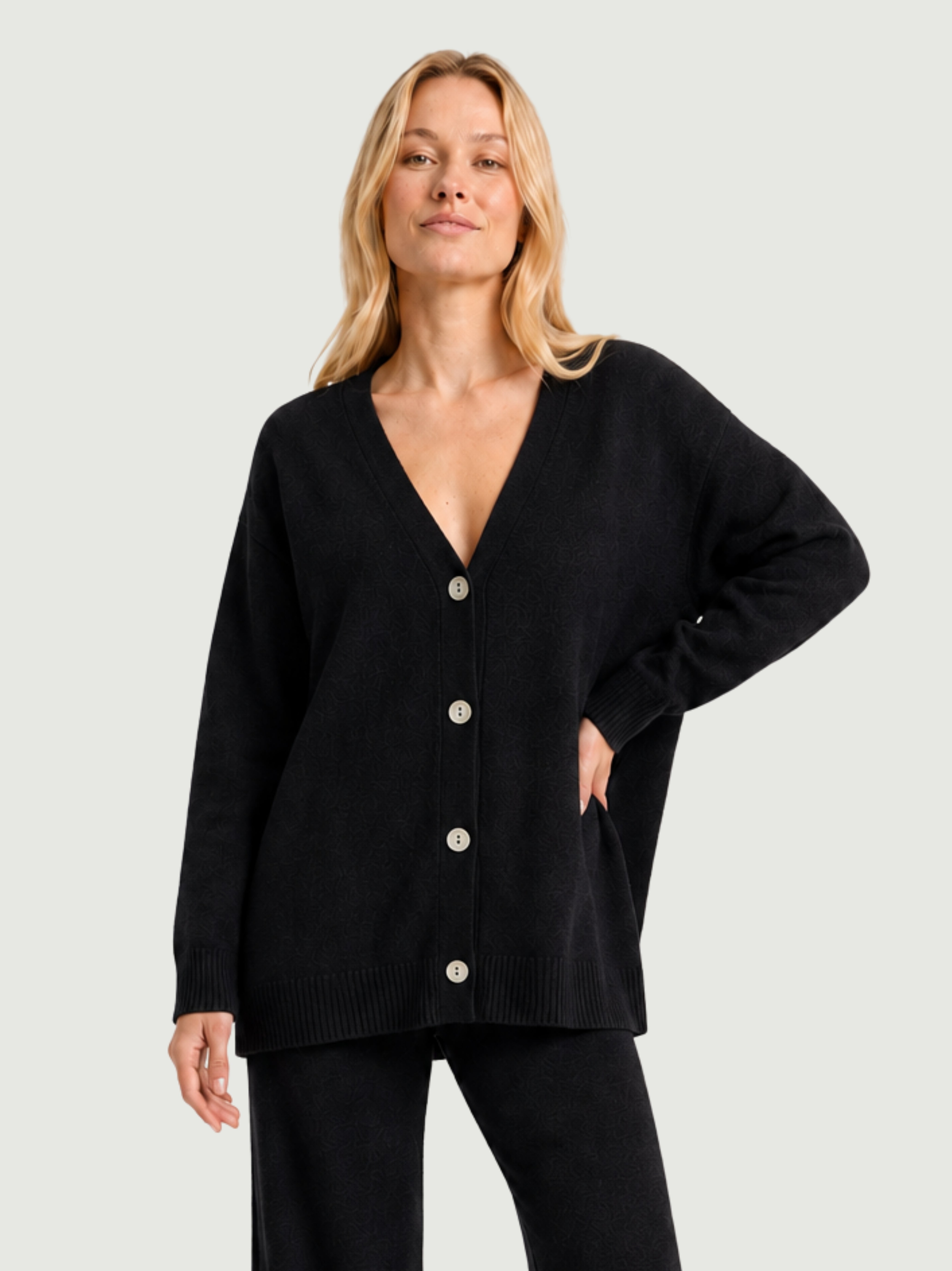 Modella indossa cardigan over nero, scollo a V, manica lunga con polsino a costine, chiusura con bottoni effetto madreperla SARA - BiMOR