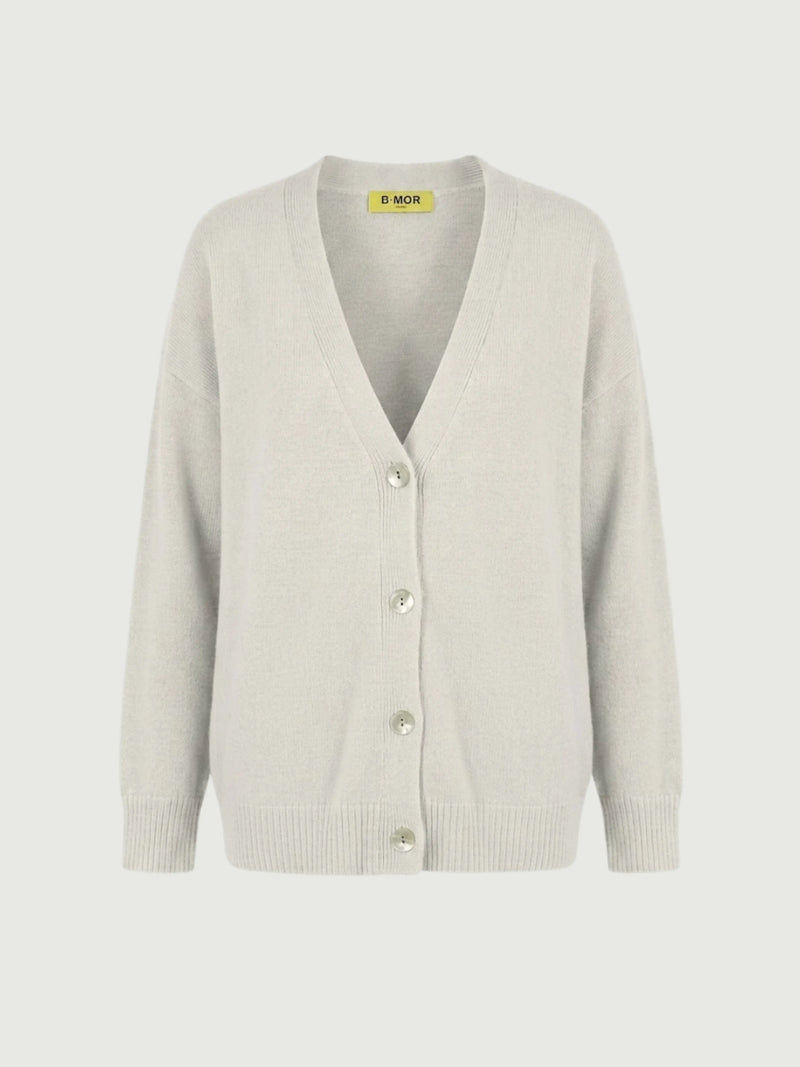 Vista frontale cardigan over bianco panna, scollo a V, manica lunga con polsino a costine, chiusura con bottoni effetto madreperla