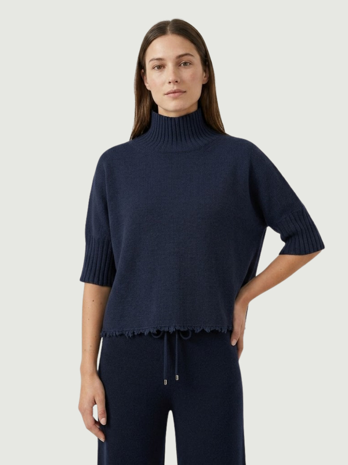 Modella indossa maglia lupetto blu scuro con manica a tre quarti e fondo sfrangiato FRA - BiMOR