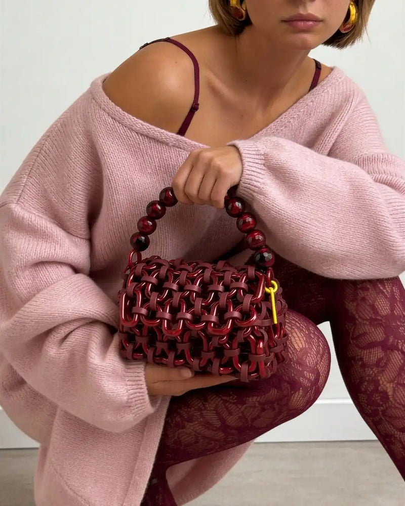 modella indossa borsa a mano in resina rosso metallizzato