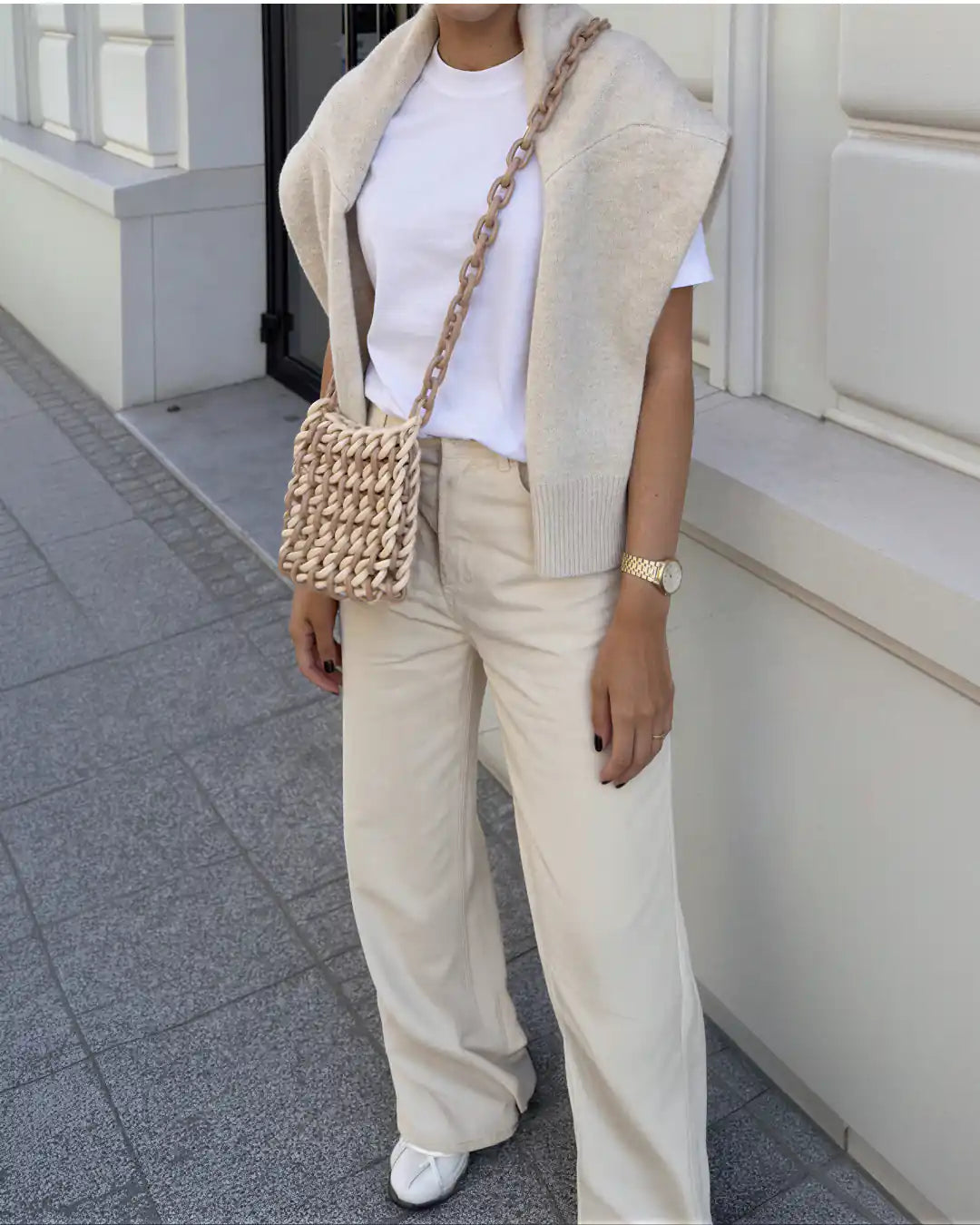 modella indossa borsa a tracolla in resina beige