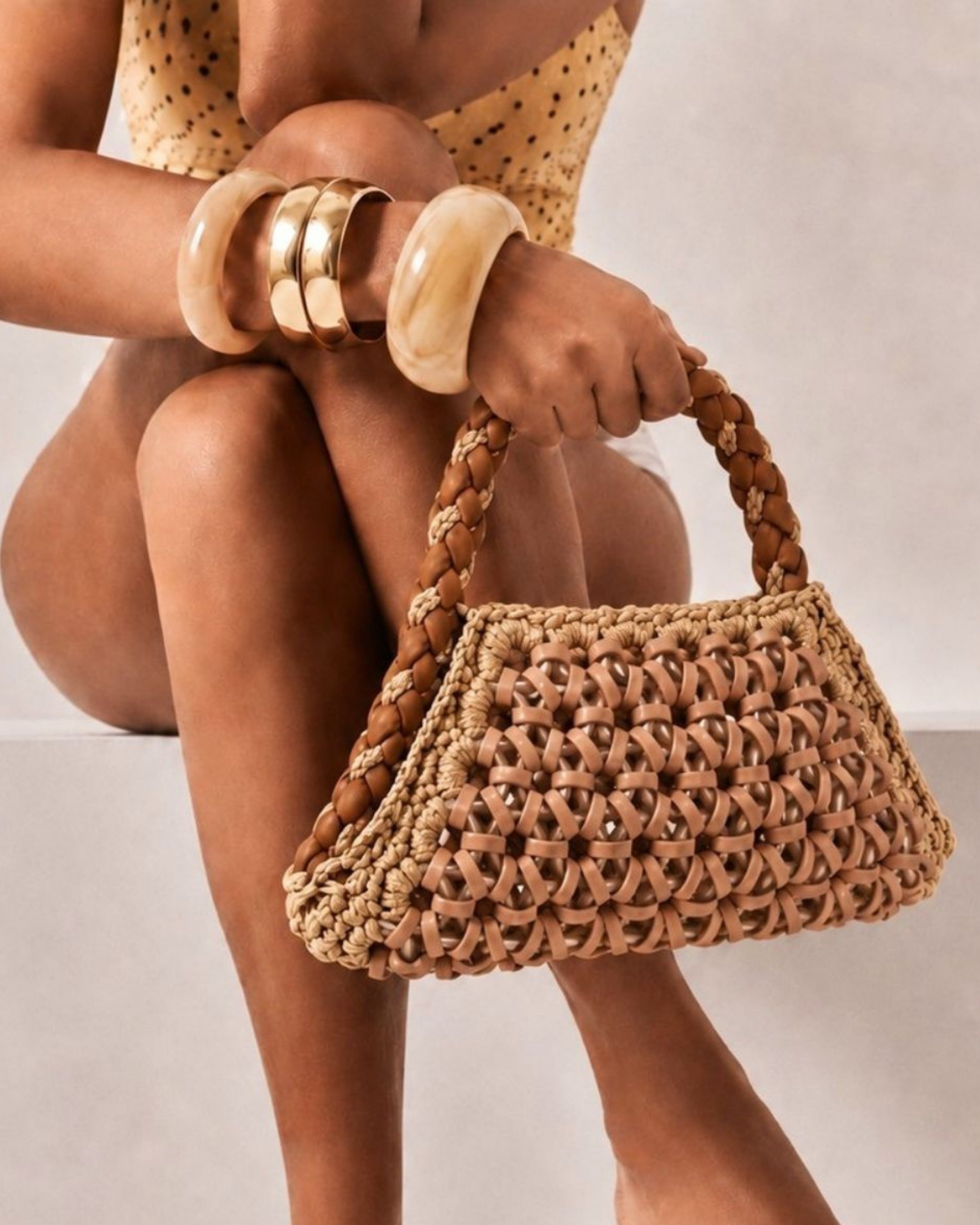 modella indossa borsa a mano in resina, pelle e cotone beige