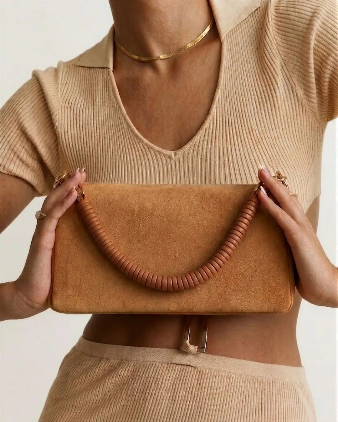 modella indossa borsa a spalla in camoscio marrone chiaro con manico in pelle marrone