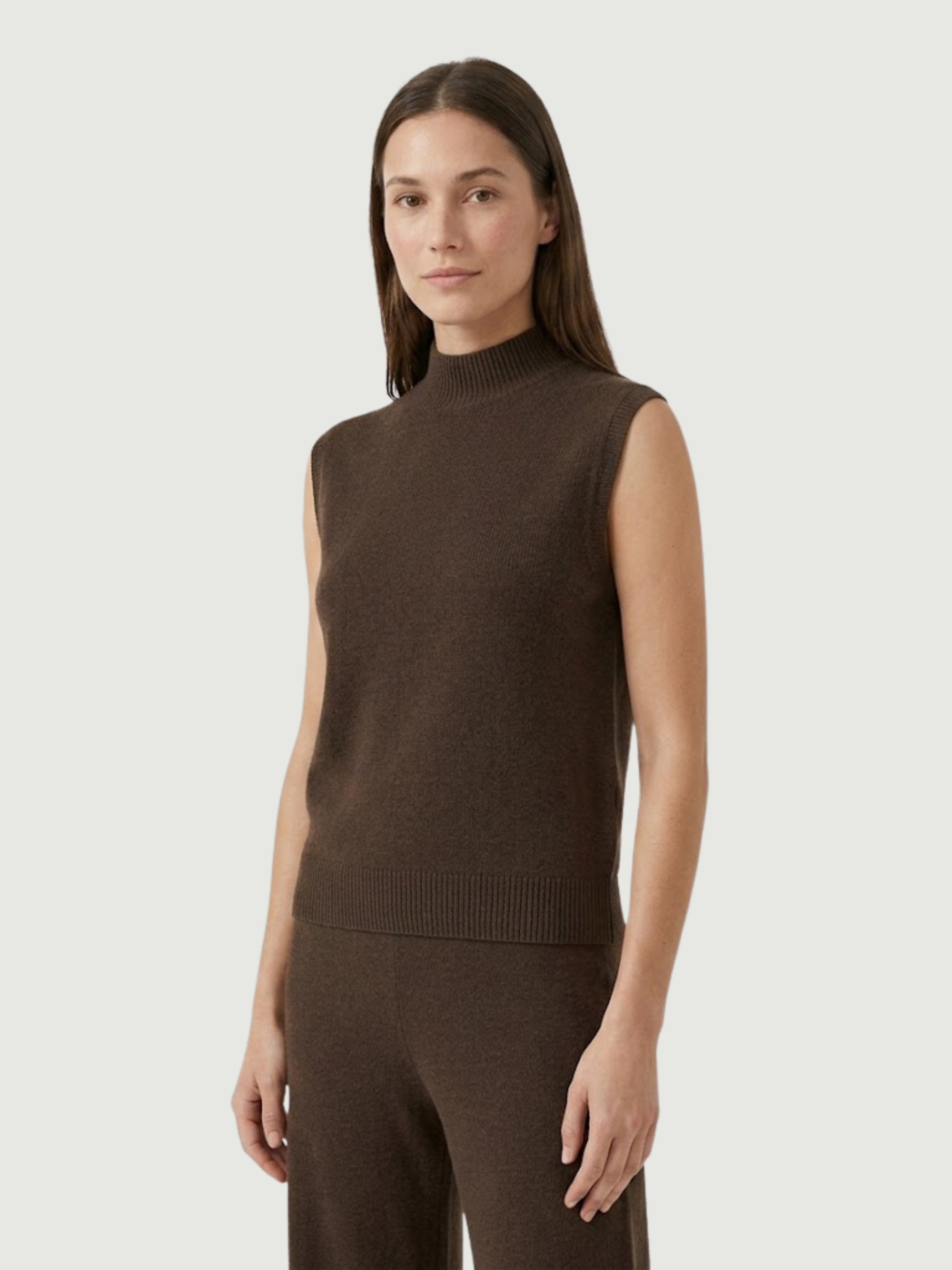 Vista laterale modella indossa gilet smanicato con collo a lupetto marrone