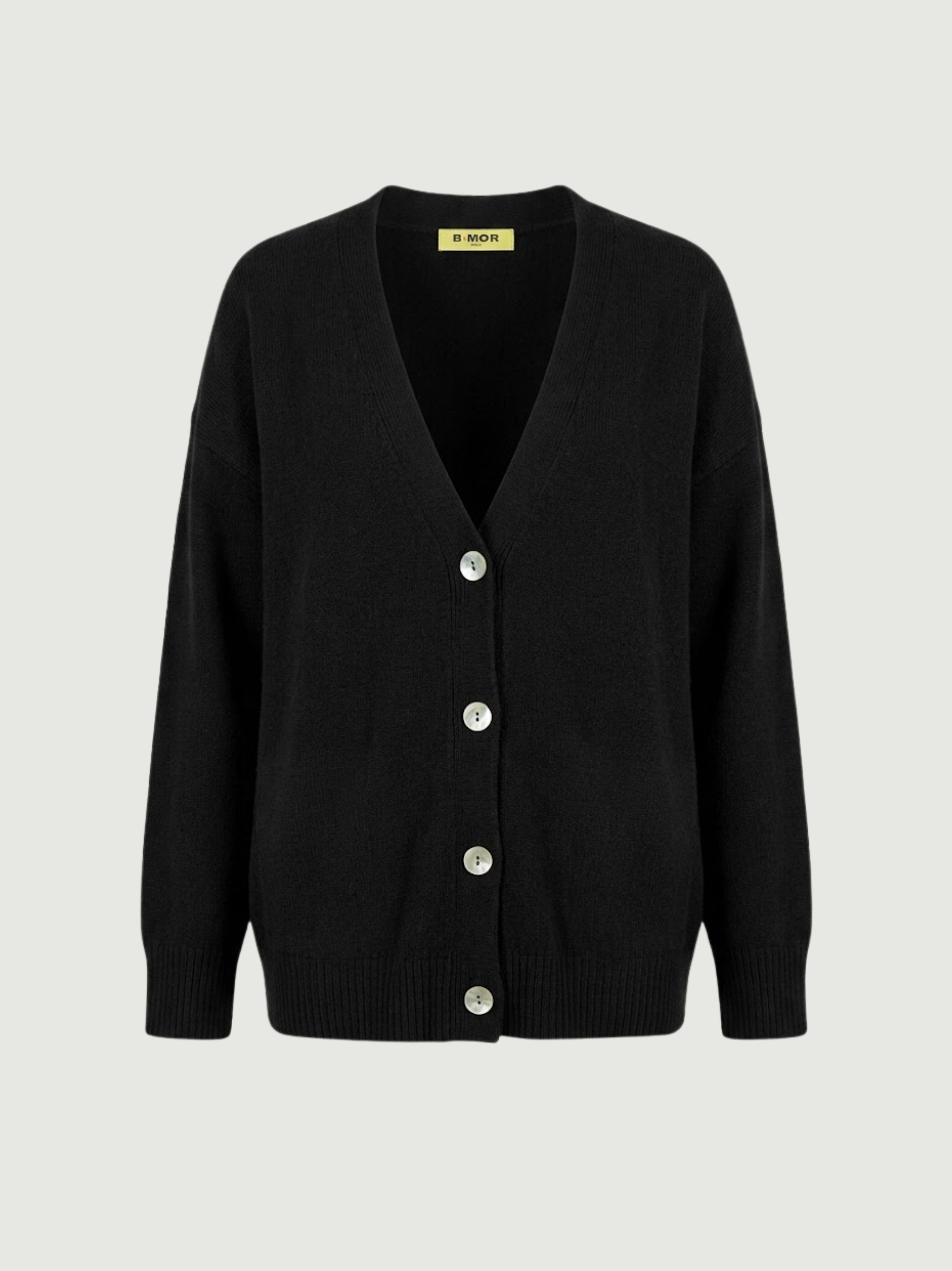 Vista frontale cardigan over nero, scollo a V, manica lunga con polsino a costine, chiusura con bottoni effetto madreperla