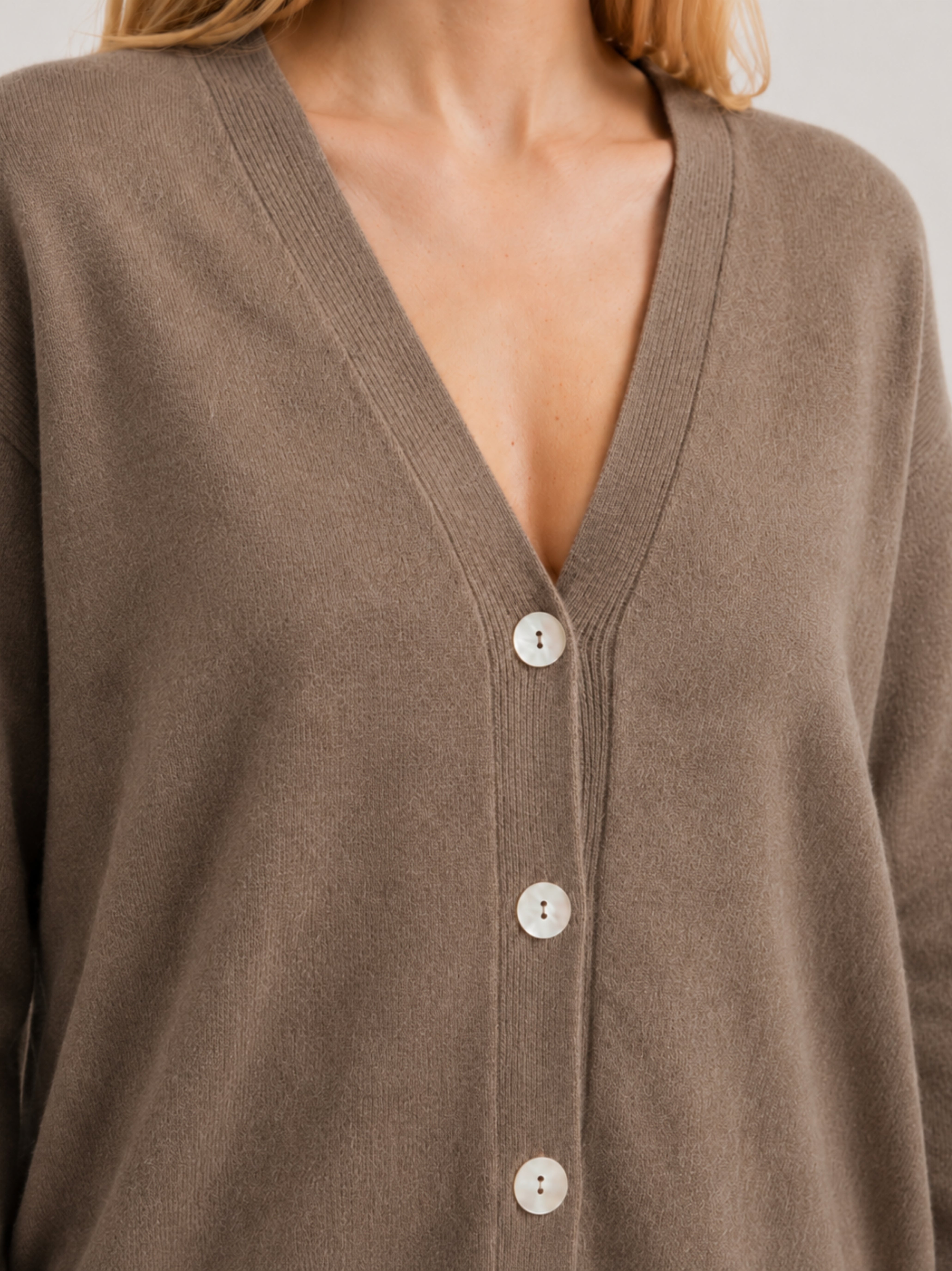 Dettaglio cardigan over nocciola, scollo a V, manica lunga con polsino a costine, chiusura con bottoni effetto madreperla
