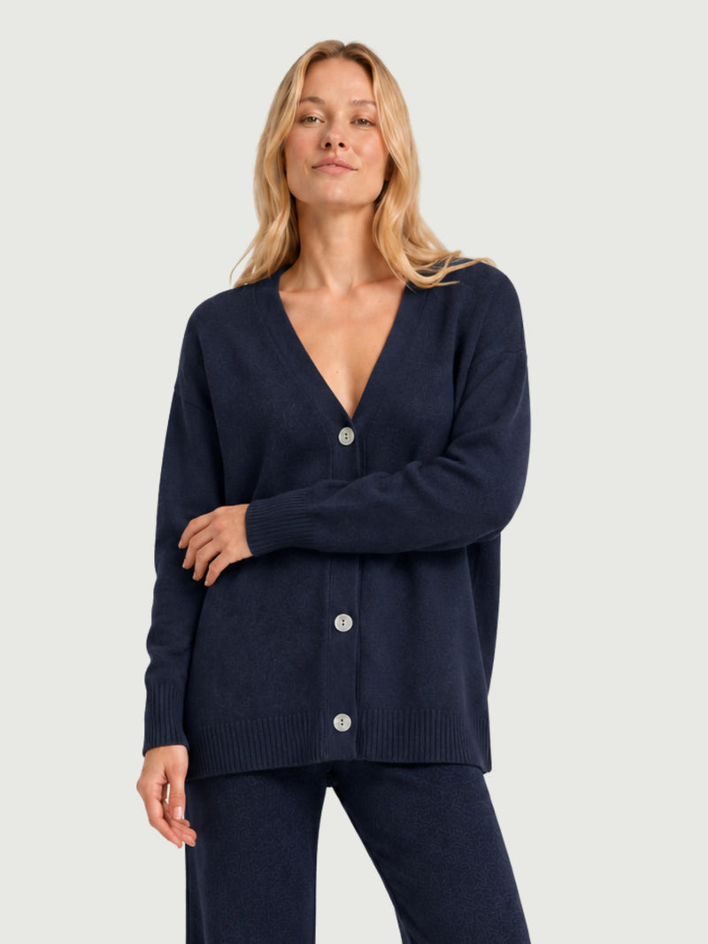Modella indossa cardigan over blu scuro, scollo a V, manica lunga con polsino a costine, chiusura con bottoni effetto madreperla SARA - BiMOR