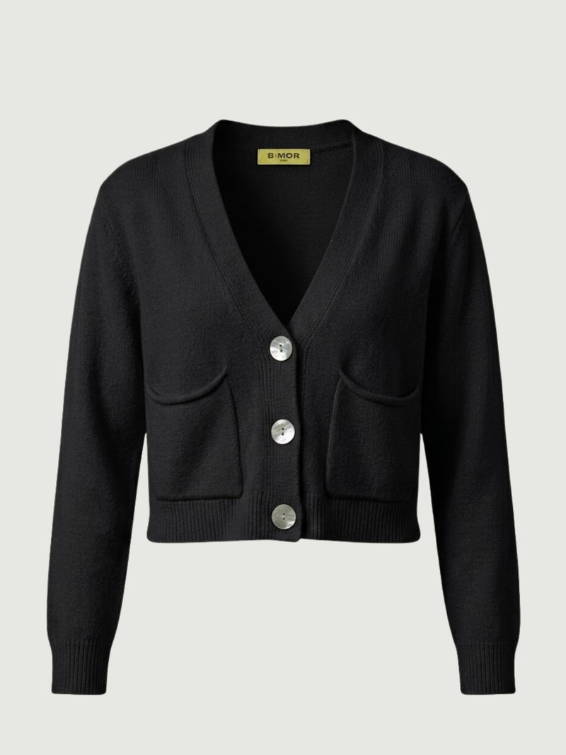 Vista frontale cardigan cropped nero con scollo a V, chiusura frontale con bottoni effetto madreperla, taschini applicati