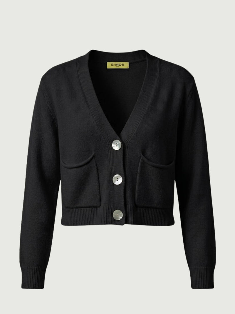 Vista frontale cardigan cropped nero con scollo a V, chiusura frontale con bottoni effetto madreperla, taschini applicati