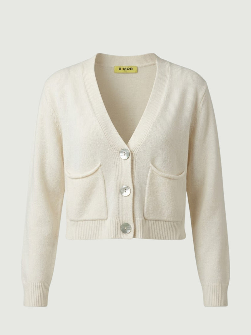 Vista frontale cardigan cropped bianco panna con scollo a V, chiusura frontale con bottoni effetto madreperla, taschini applicati