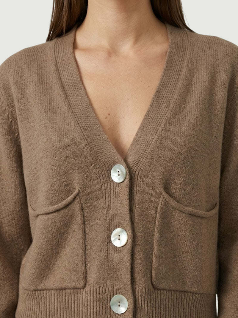 Dettaglio cardigan cropped nocciola con scollo a V, chiusura frontale con bottoni effetto madreperla, taschini applicati