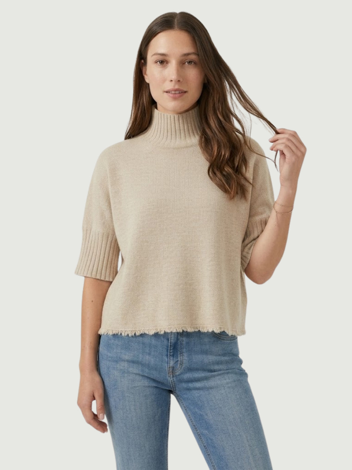 Modella indossa maglia lupetto beige con manica a tre quarti e fondo sfrangiato FRA - BiMOR