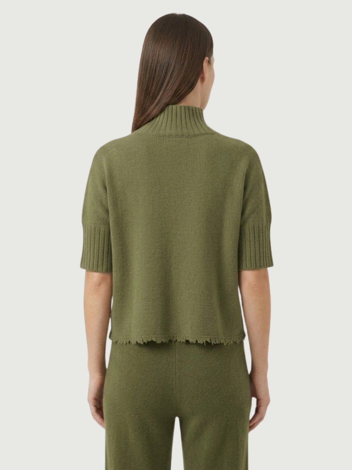 Vista posteriore modella indossa maglia lupetto verde oliva con manica a tre quarti e fondo sfrangiato