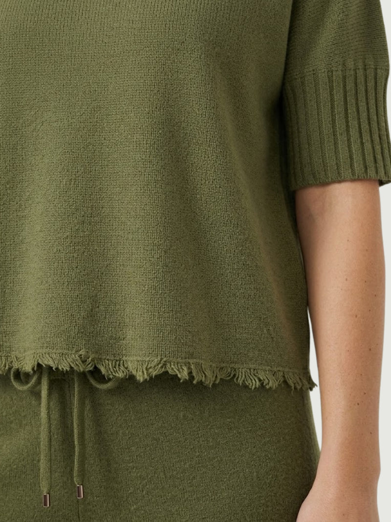 Dettaglio maglia lupetto verde oliva con manica a tre quarti e fondo sfrangiato