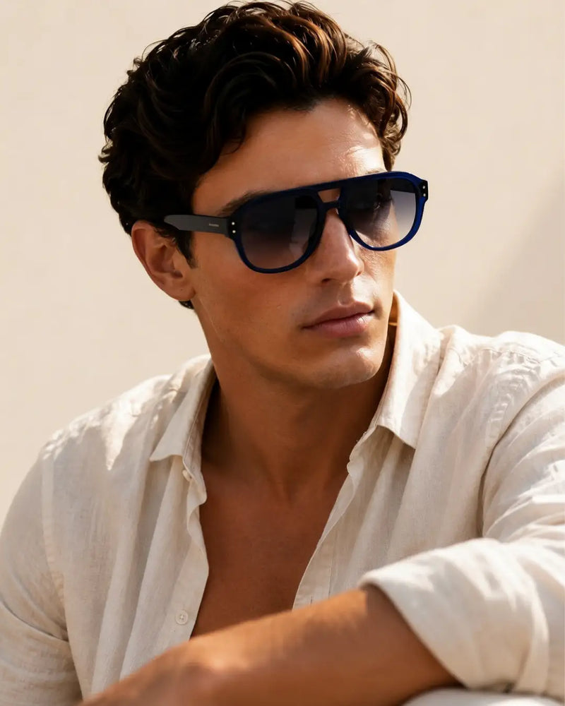 modello indossa occhiale da sole aviator arrotondato doppio ponte, montatura in acetato blu lucido, lenti blu sfumate