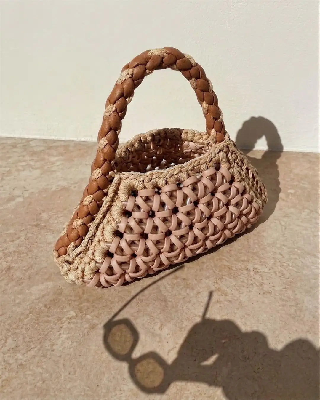 borsa a mano in resina, pelle e cotone beige appoggiata